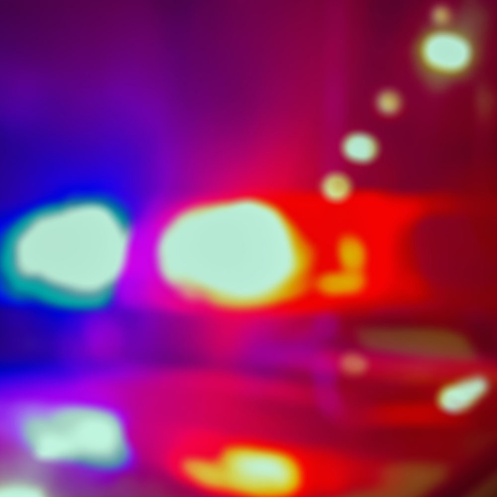 A blurry image of the roof of a police car with blue and red lights flashing