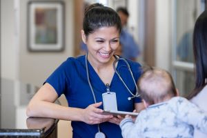 A nurse looks at a baby