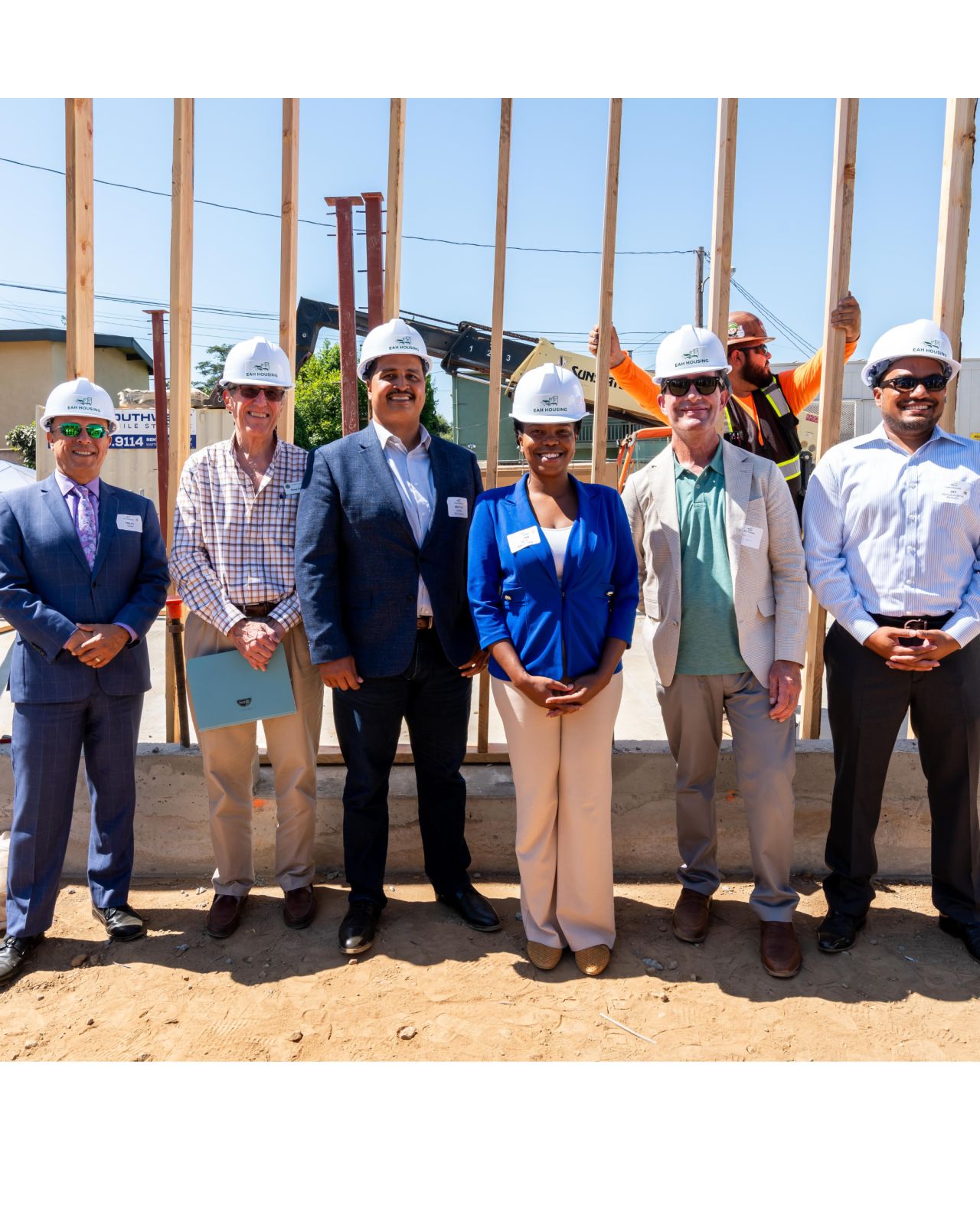 EAH and associates in front of wall raising