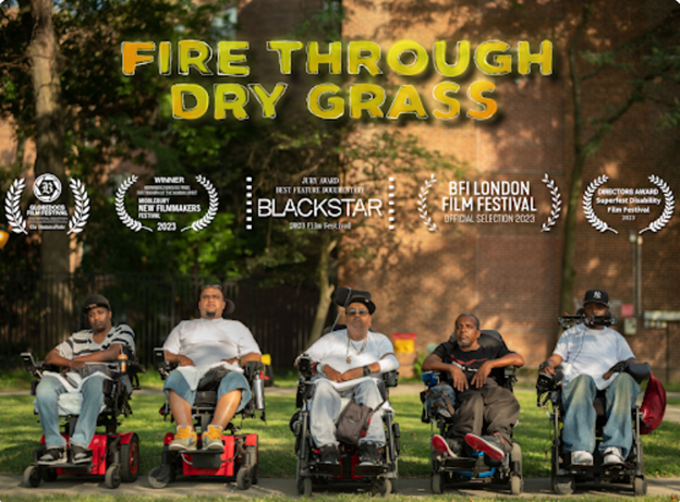 This image is a promotional poster for a film titled ‘Fire Through Dry Grass.’ The poster features five men sitting in power wheelchairs outdoors, arranged in a line, facing the camera. They appear to be part of a close-knit community. The background shows trees and a building, suggesting an urban park setting. Above them, in bold yellow letters, is the film's title. Surrounding the title are various film festival laurels, indicating the film's selection and awards at events such as the BlackStar Film Festival, BFI London Film Festival, and Directors Guild of America. The overall tone of the poster suggests a powerful and compelling story centered on the experiences of these men