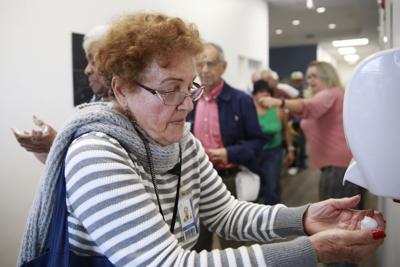 Photo of woman sanitizing hands.