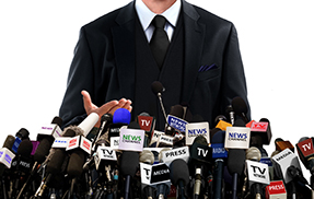 Image of a man standing in front of microphones