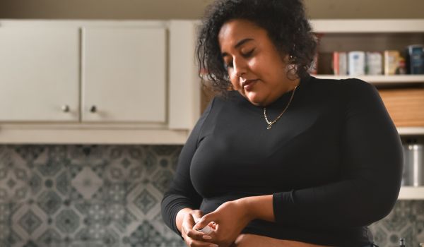 A woman with obesity gives herself a shot in her abdomen