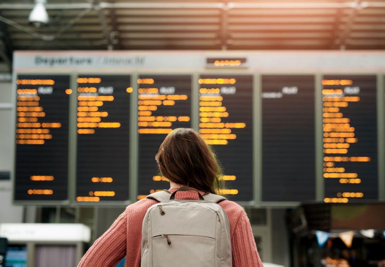 A woman at an airport looks at flight information.