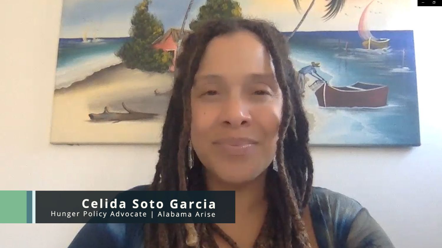 A black woman with brown dreadlocks speaks to the camera