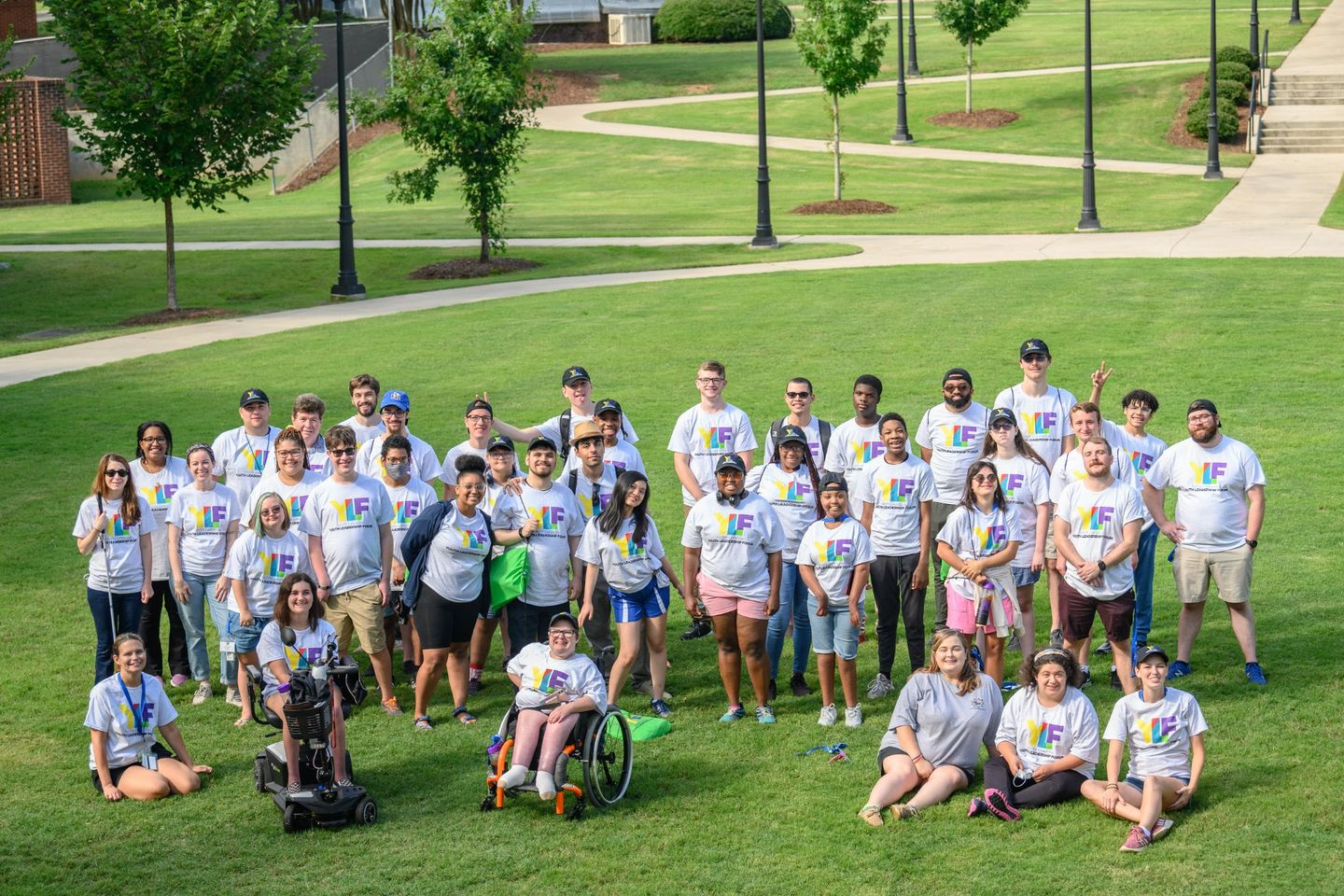 Youth with disabilities in matching YLF shirts smiling while outside.