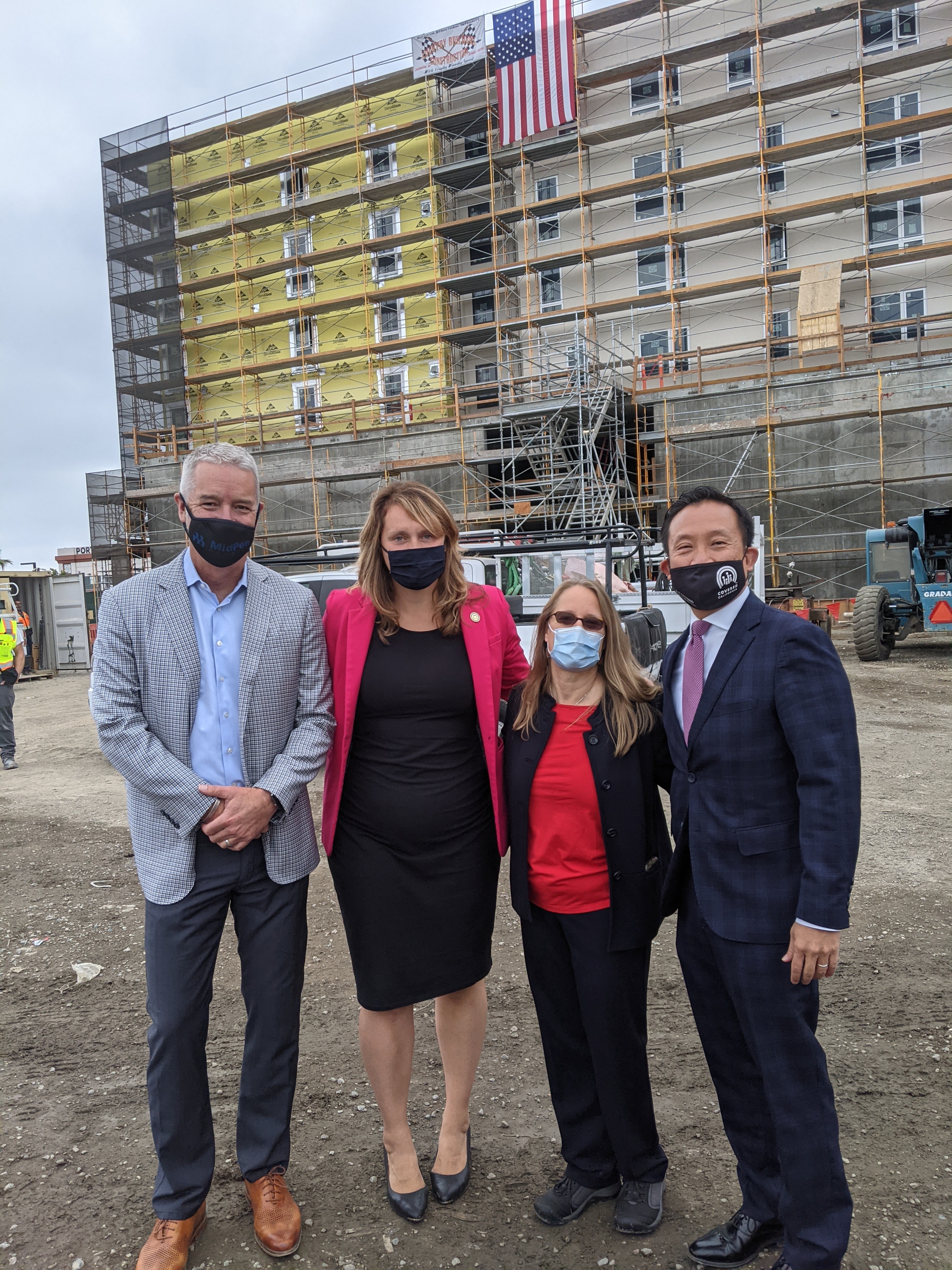 Amie Fishman standing with state lawmakers in front of new development site.