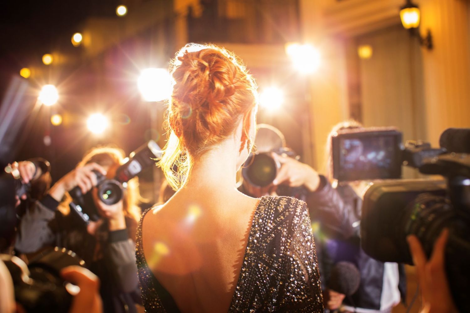 A female celebrity being photographed at an event.