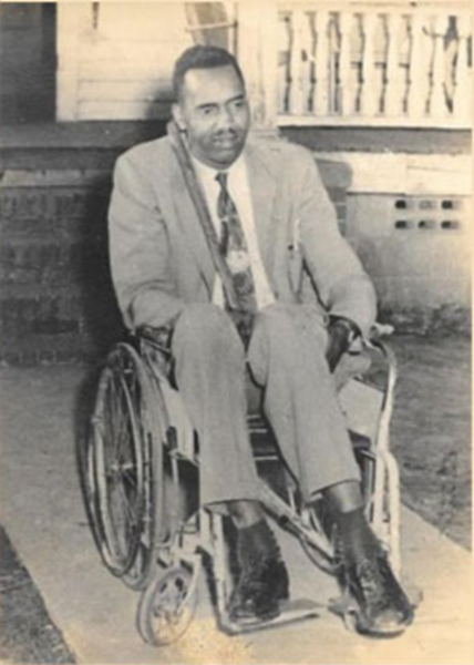 Black and white photo of Reverend Ivory, a Black man in a suit using a wheelchair.