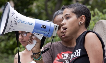 An activist speaking at a megaphone.