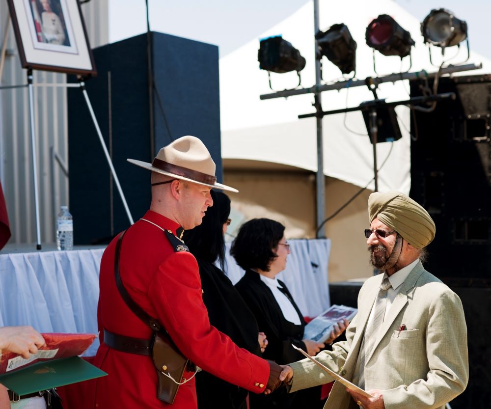 A new Canadian citizen greets a Royal Canadian Mounted Police officer at a citizenship ceremony in Ontario.