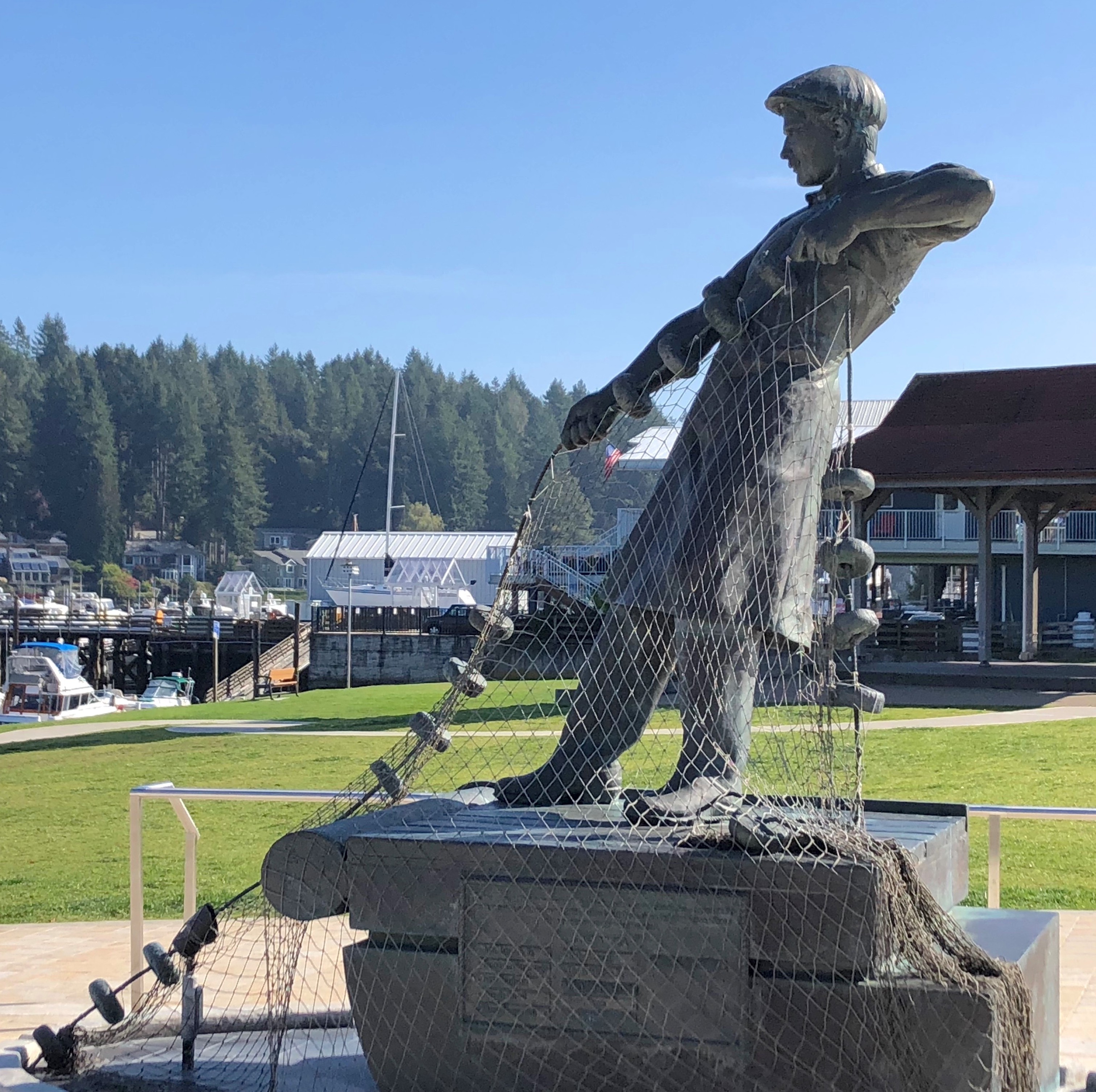 A statue at the park next door to Gig Harbor Marina shows a fisherman reeling in a net.