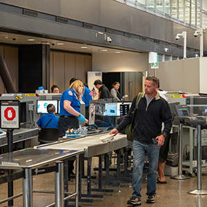 TSA security checkpoint with passengers moving through screenings