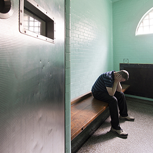 Image of an individual in a jail cell.