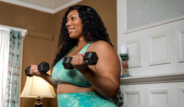 Photo of a woman lifting weights in her home