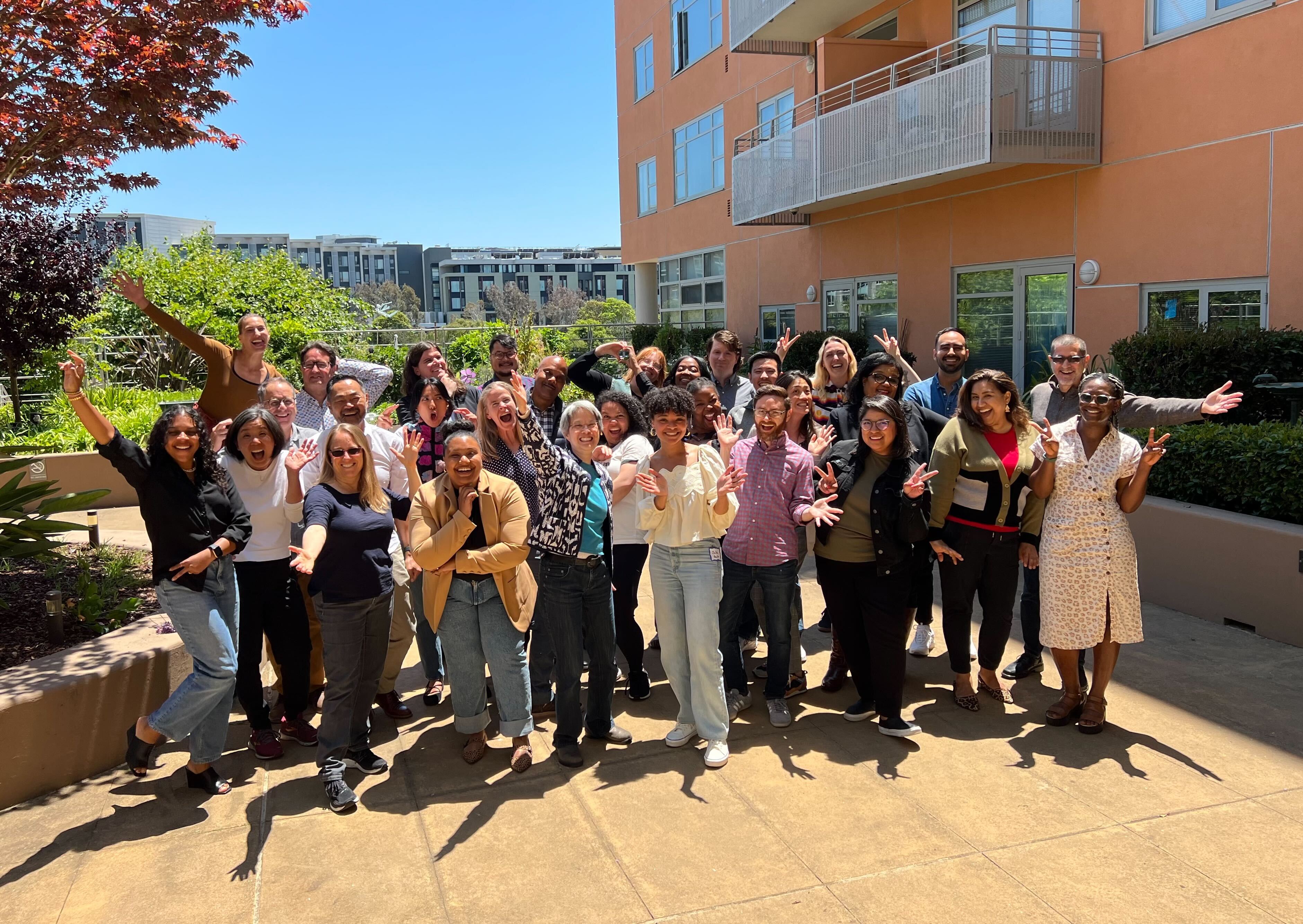 NPH staff as a group smiling in a sunlit area.