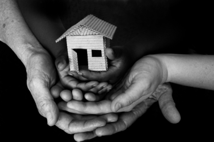 Photo of hands holding a house.