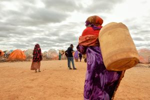 A displaced woman walks with a jerrycan of water in Somalia.