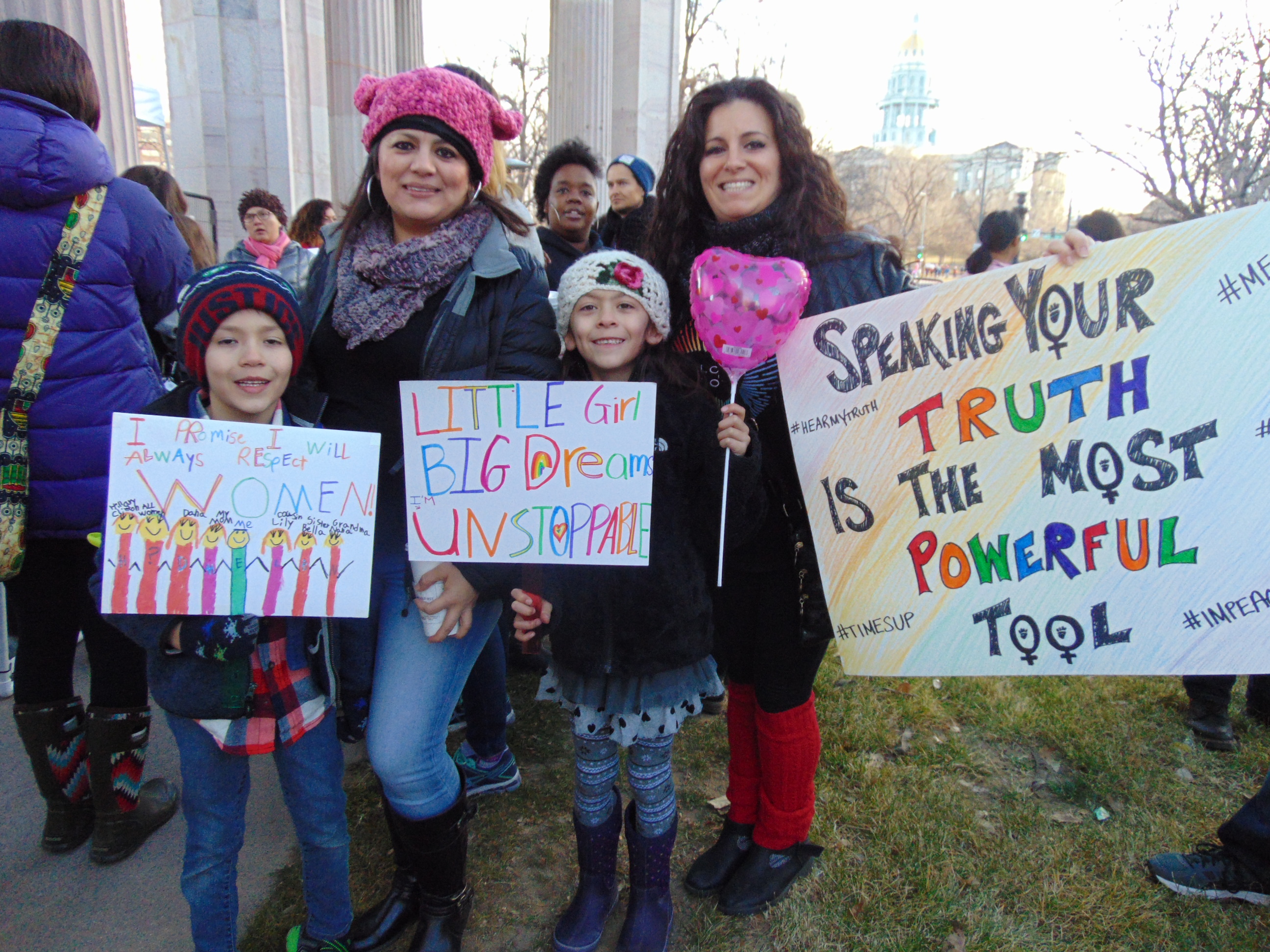 A group of activists holding signs to advocate for gender equity and rights.