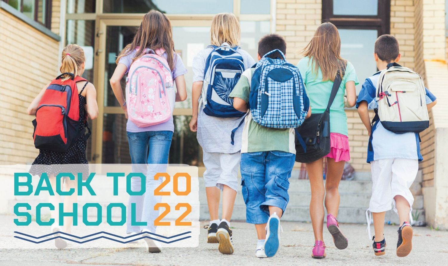 Row of kids wearing backpacks and walking into a school