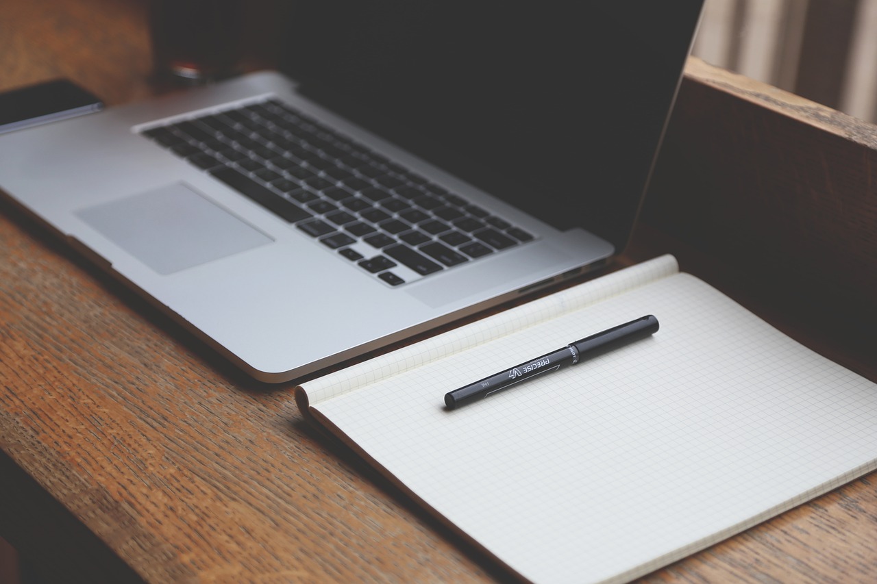 Laptop and notebook on a desk