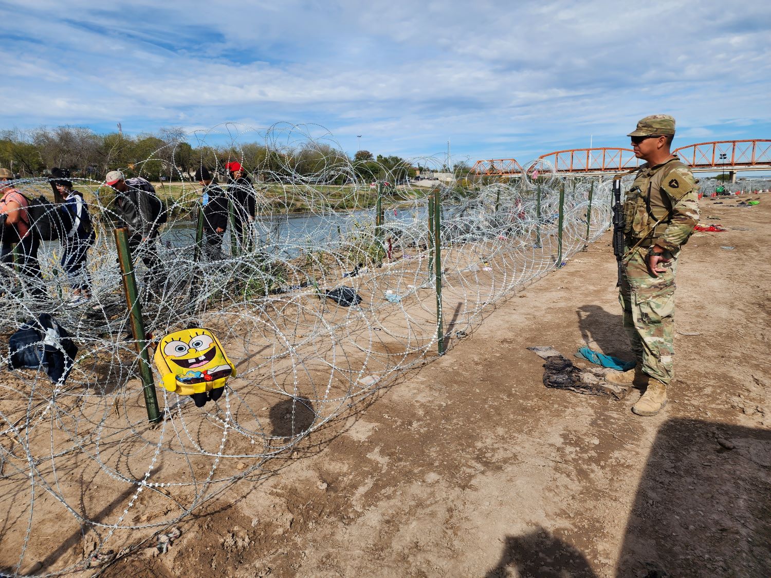 A member of the Texas National Guard faces migrants in Eagle Pass, Texas.