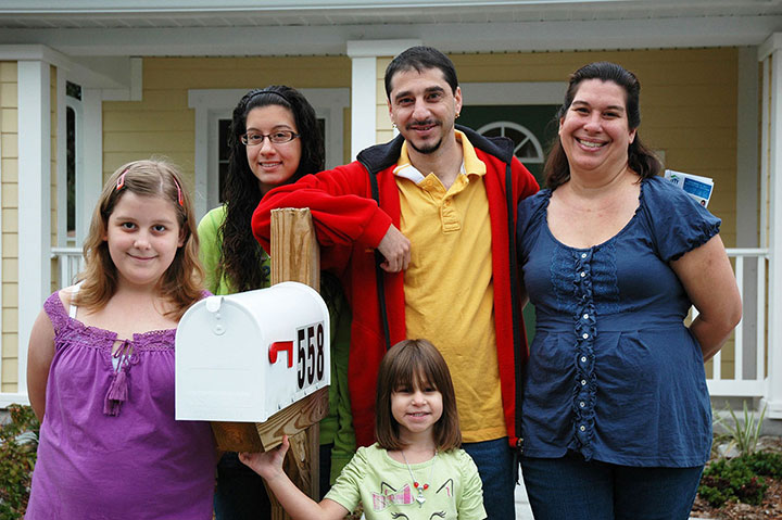 Photo of family in front of a house.