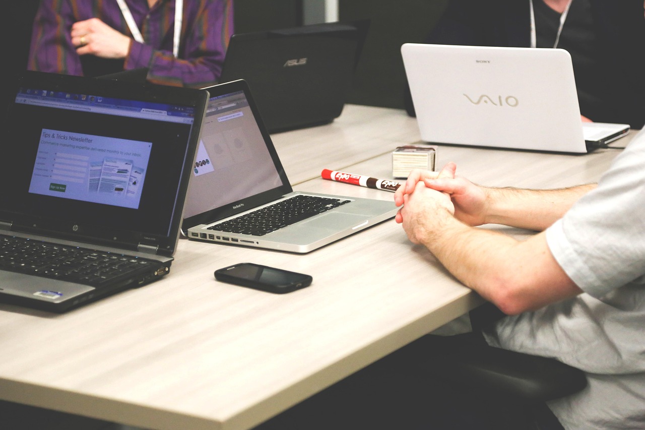 Group at desk on laptops during a meeting