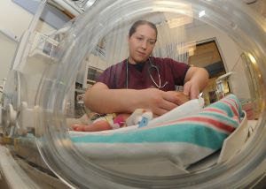 An intern examines a newborn baby in the Neonatal Intensive Care Unit
